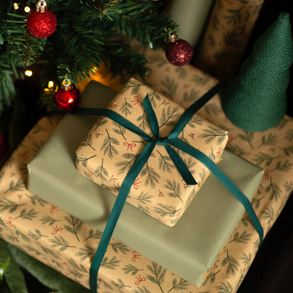 Gifts under a decorated Christmas tree with ribbons and ornaments.