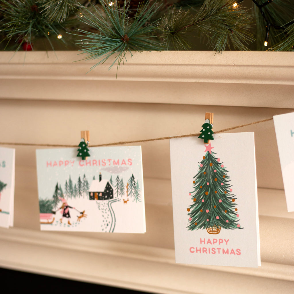 Christmas cards hanging on a string with a fireplace background