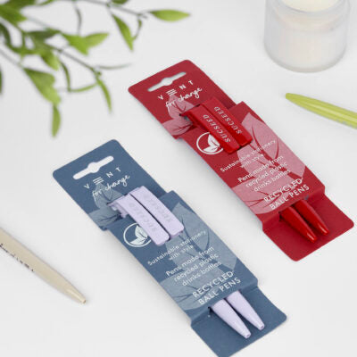 Purple and red pens lying on a white table