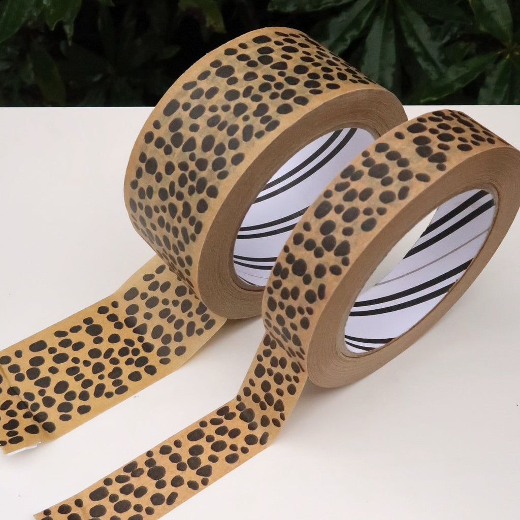 rolls of paper tape on a white table in front of a green plant