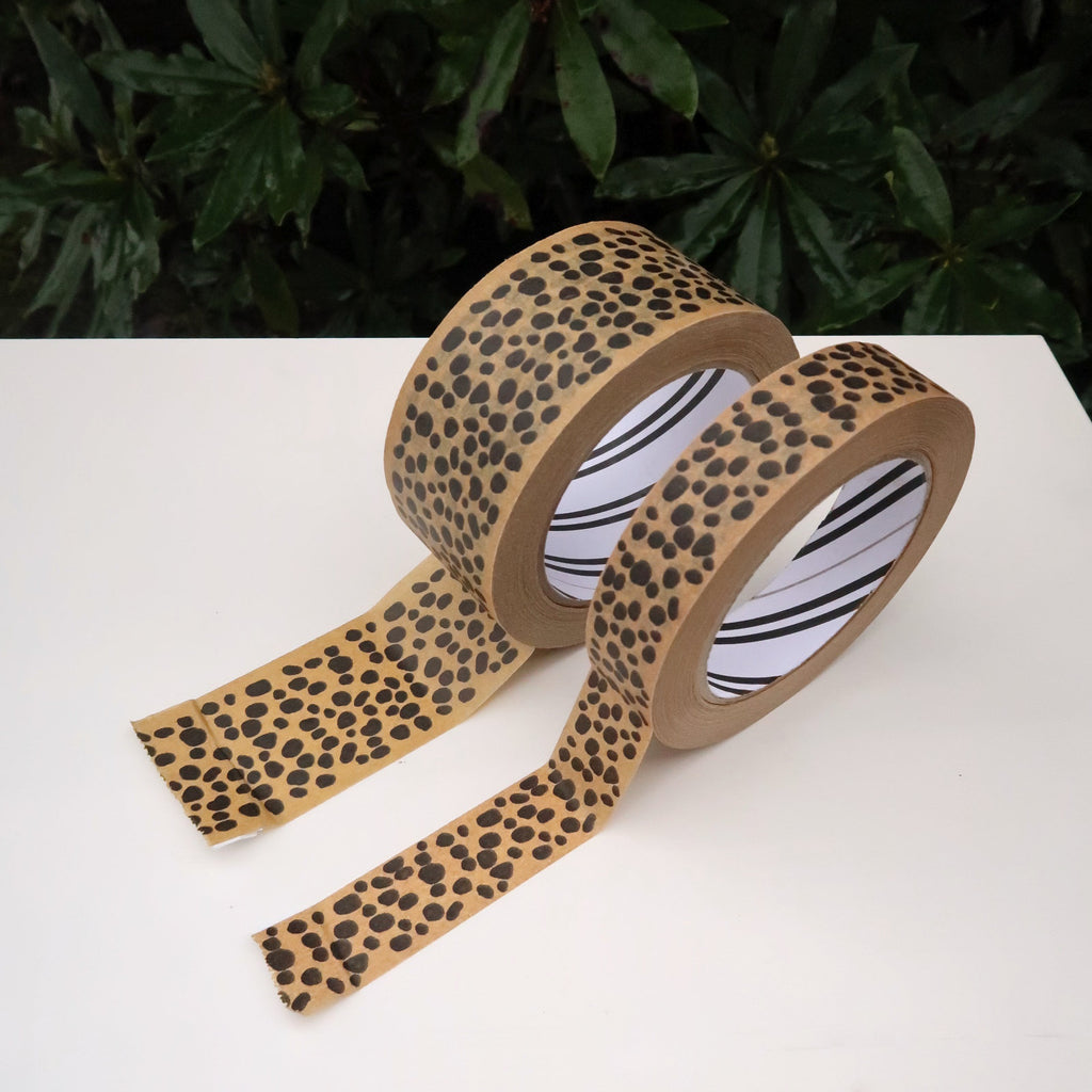 rolls of paper tape on a white table in front of a green plant