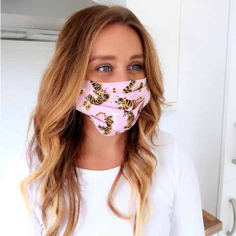 pretty girl with long brown hair wearing a reusable pink tiger face mask