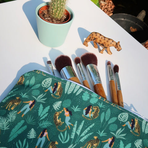green leopard print zip bag with bamboo make up brushes sticking out of it