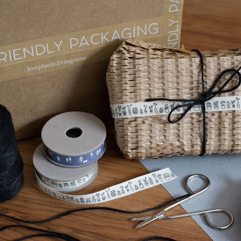 beautifully wrapped parcel surrounded by eco friendly packaging products 