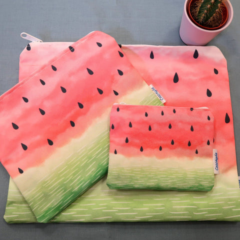 3 colourful watermelon design zip bags ona table next to a cactus