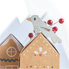 Decorative birdhouse with a bird on top and red berries in the background