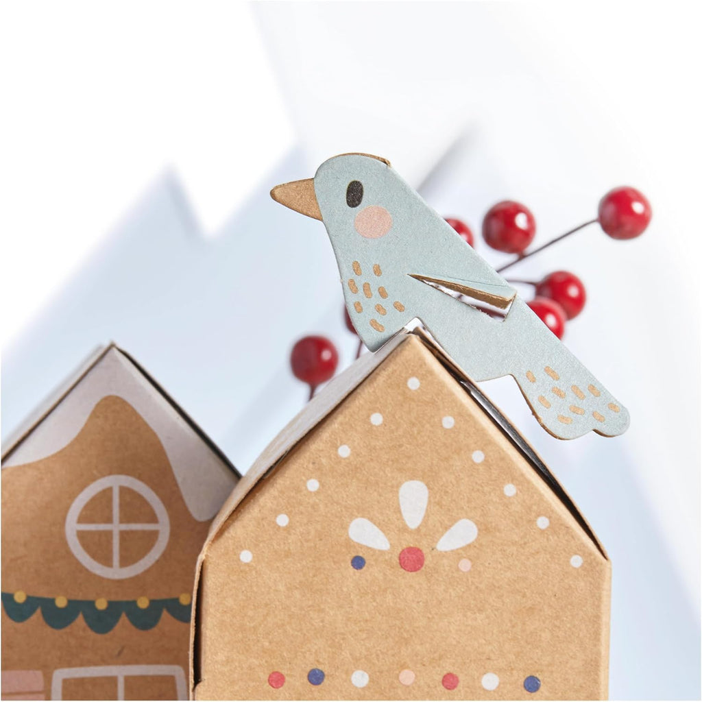 Decorative birdhouse with a bird on top and red berries in the background