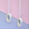 Two rolls of washi tape with a blue and white floral pattern, hanging vertically against a split pastel pink and lavender background.