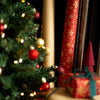 Decorative Christmas scene with a tree, wrapped gifts, and ribbons.