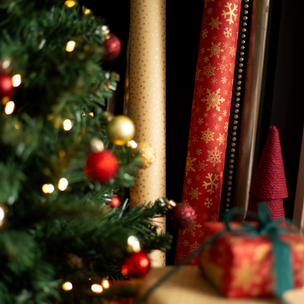 Decorative Christmas scene with a tree, wrapped gifts, and ribbons.