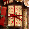 Christmas-themed gift wrap with red ribbon on a wooden surface.