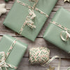 Green gift boxes with decorative ribbons on a wooden surface