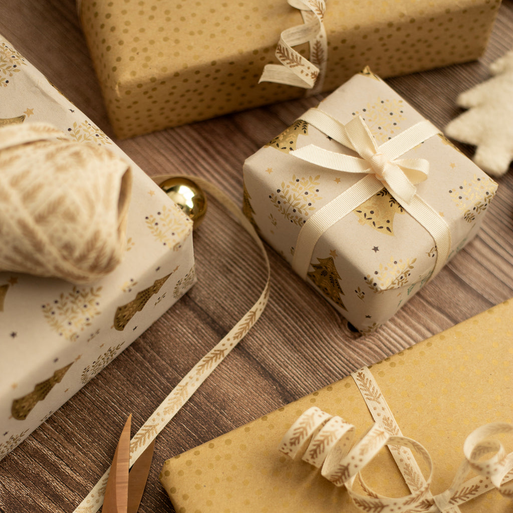 Gift boxes wrapped in decorative paper with ribbons on a wooden surface