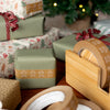 Close-up of wrapped Christmas presents with gingerbread design on a wooden surface.