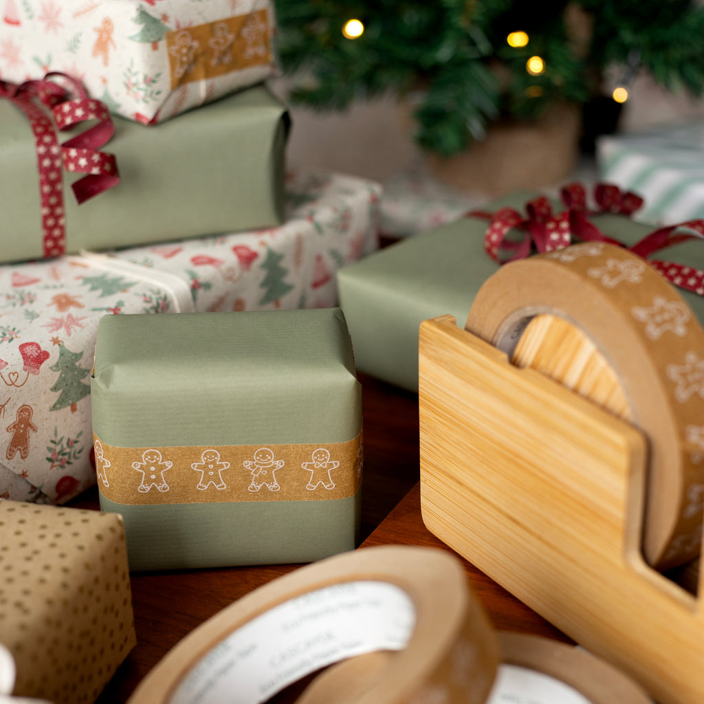 Close-up of wrapped Christmas presents with gingerbread design on a wooden surface.