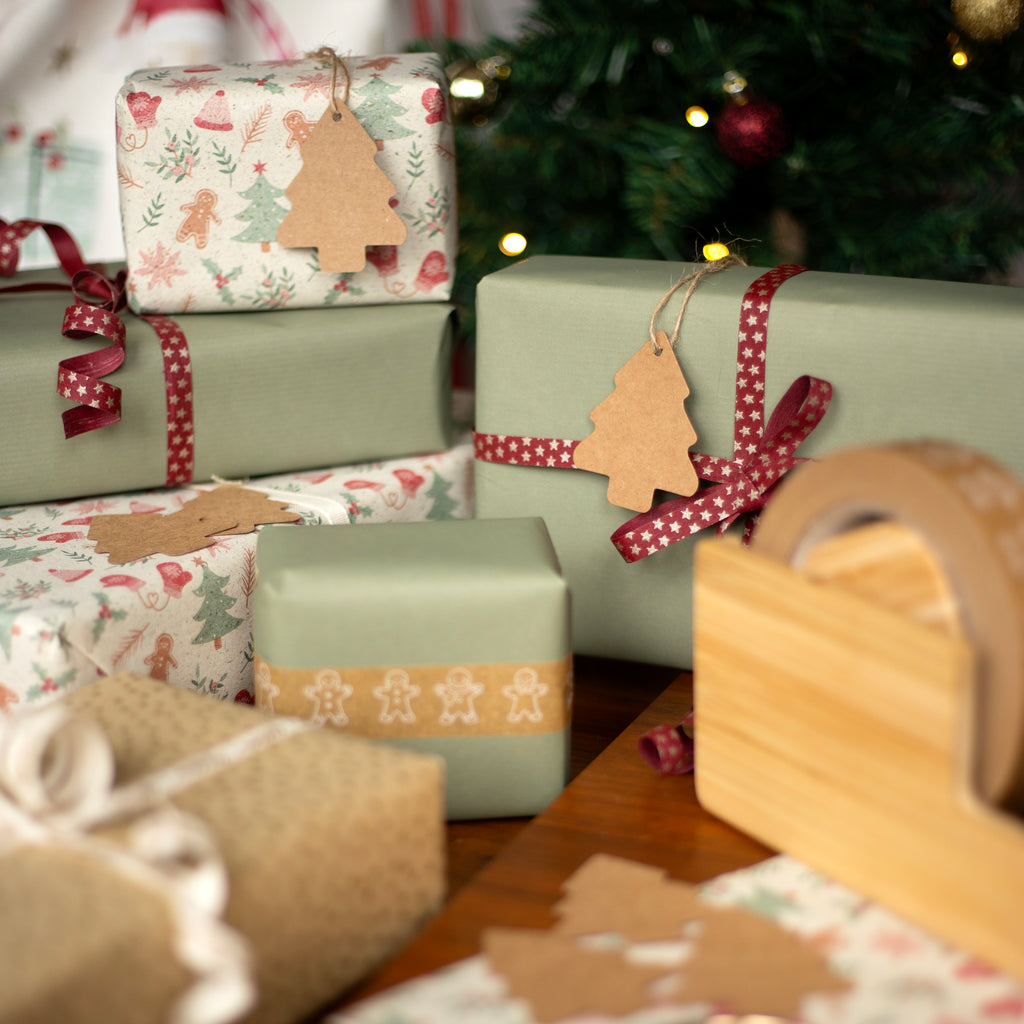 Christmas presents wrapped in festive paper with ribbons and tree tags on a wooden table.