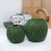 2 balls of green twine in front of wrapped presents