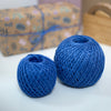 Balls of coloured jute twine bundled up against a white background