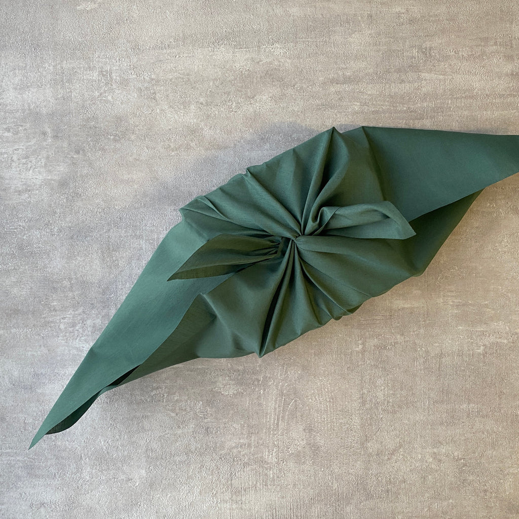a gift wrapped in green furoshiki material gift wrap