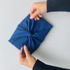 blue furoshiki material gift wrap tied by hands