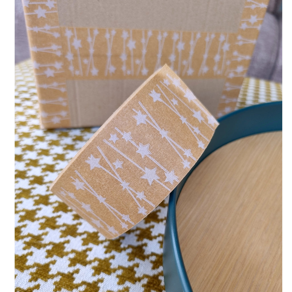 brown paper tape with white star pattern in front of a brown box