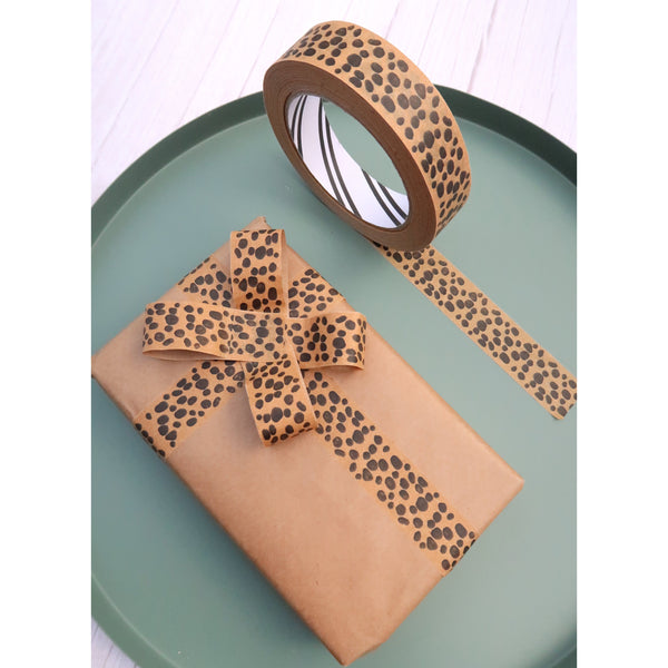 animal print patterned paper tape roll and gift with a bow sitting on a green table top
