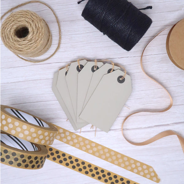 paper gift tags on a wooden table top with tring and paper tape