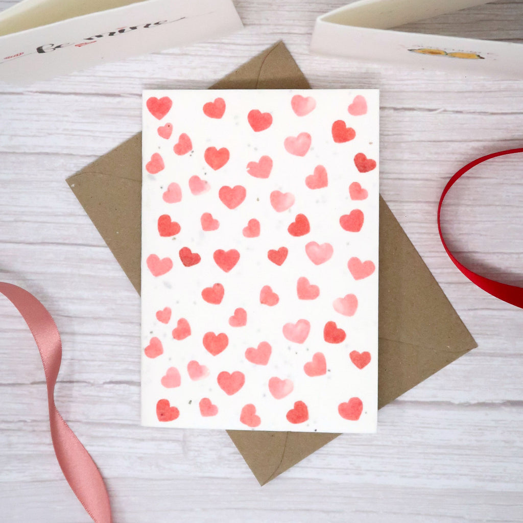Lots of small red love hearts on the front of a plantable seed paper card