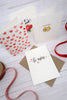 valentines cards on a white wood table with red ribbon and brown envelopes